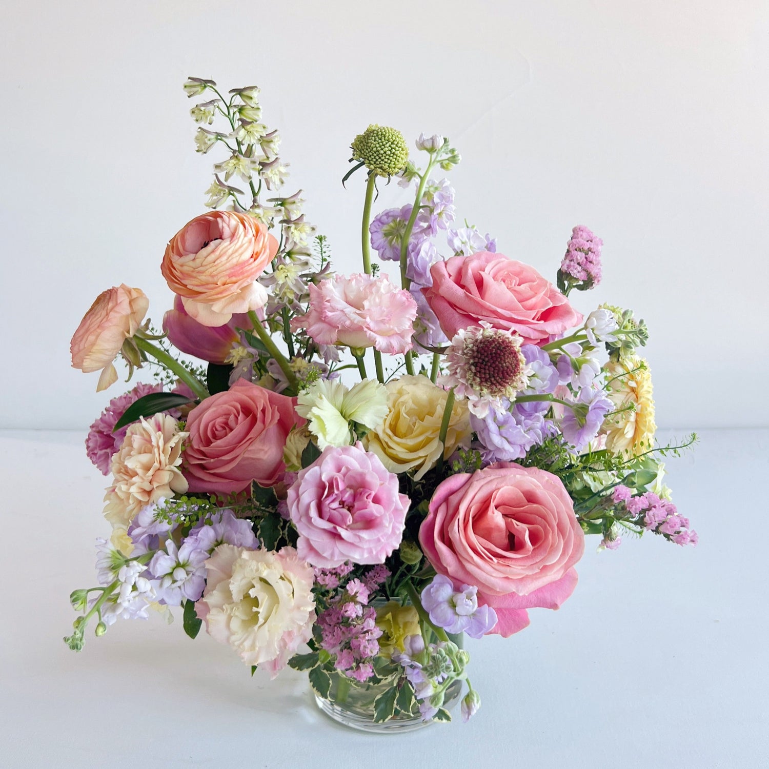 Seasonal arrangement pictured in cylindrical glass vase.  Floral centerpiece arrangement completed by Everbloom Design a Memphis, Tennessee based floral studio and gift shop.