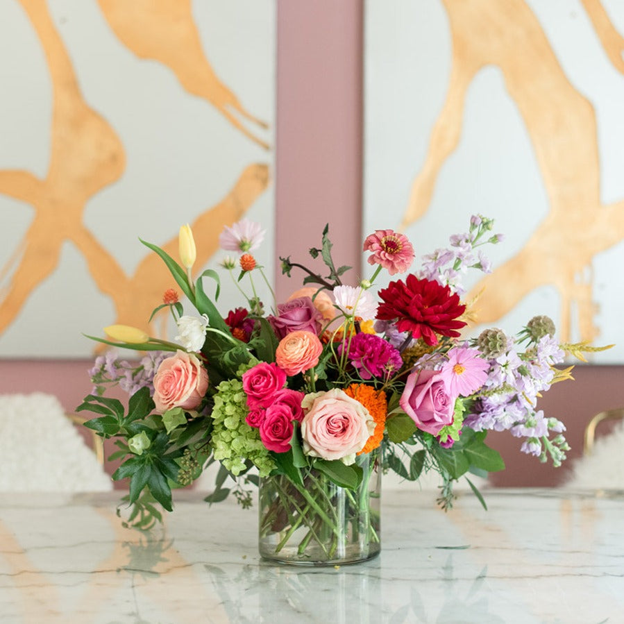 Add some flair to your decor with this exquisite seasonal arrangement in a cylindrical glass vase crafted by Everbloom Design, the top Memphis floral studio.
