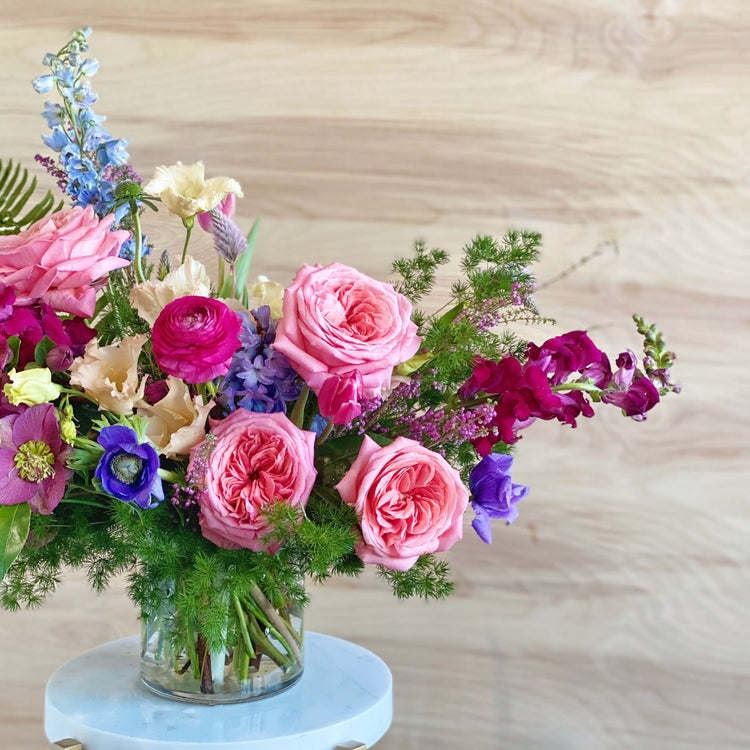 Stunning seasonal arrangement in a cylindrical glass vase crafted by Everbloom Design, the top Memphis-based floral studio.