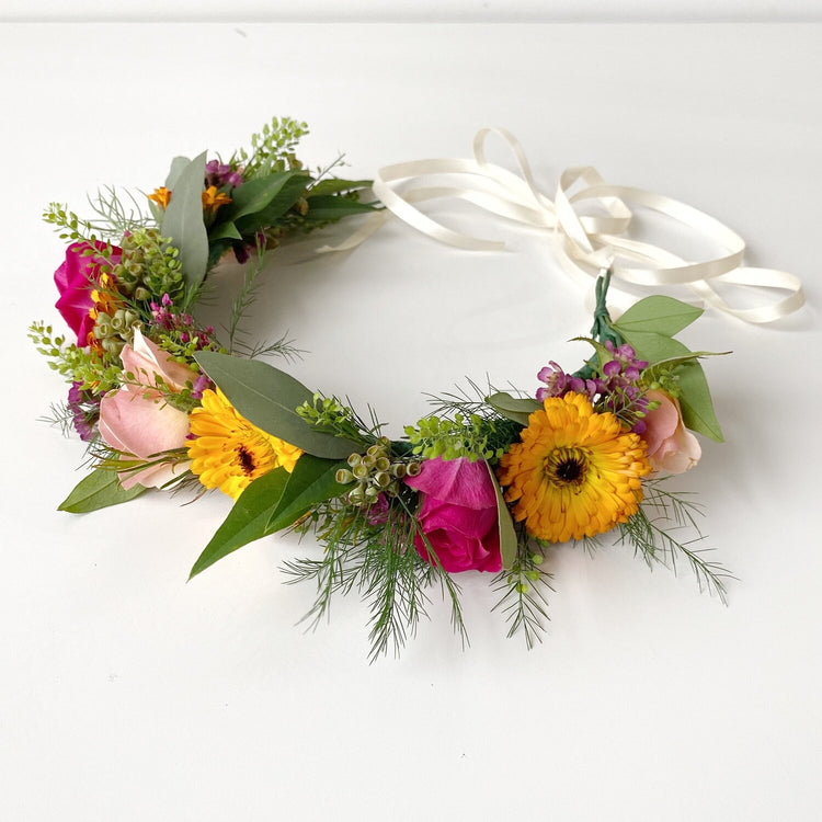 Flower crown tied with white satin ribbon featuring multiple types of fresh cut flowers. Arranged in Memphis, TN by Everbloom Design.