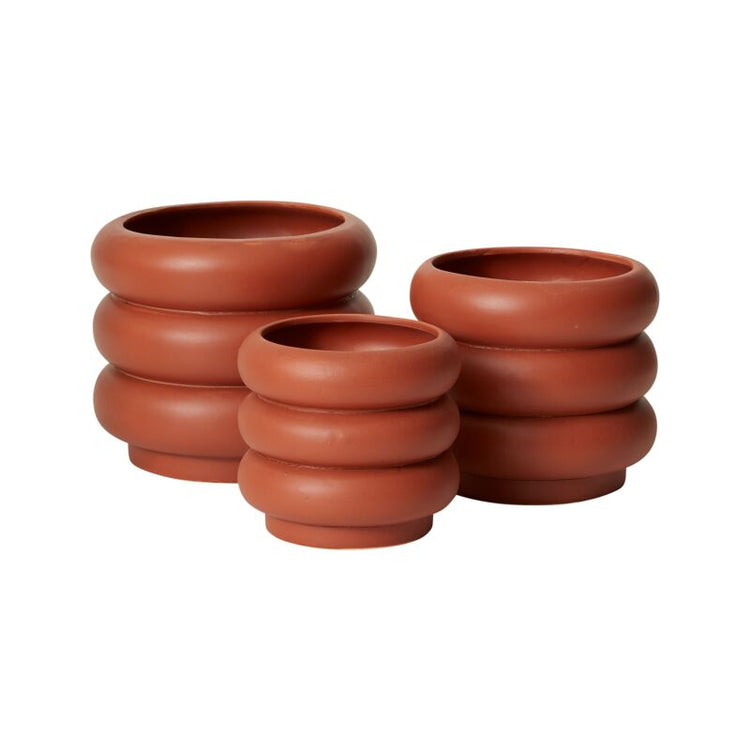 Set of three terracotta pots stacked on a white background