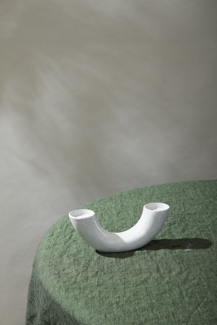 White ceramic bowl on a textured green surface with a neutral background