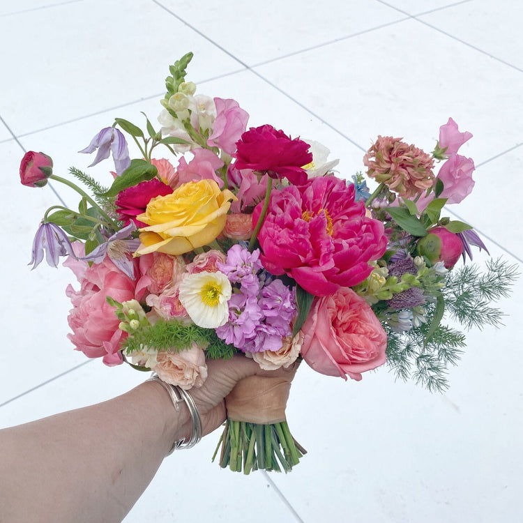 Seasonal bridal bouquet arrangement pictured held by female hand.  Floral arrangement completed by Everbloom Design a Memphis, Tennessee based floral studio.