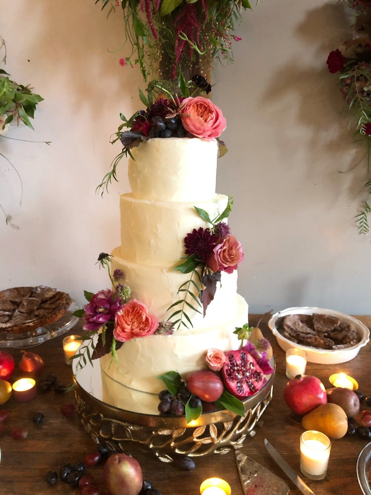 Picture of white wedding cake featuring small flower arrangements on varying levels of the cake.  Floral arrangement completed by Everbloom Design a Memphis, Tennessee flower shop.