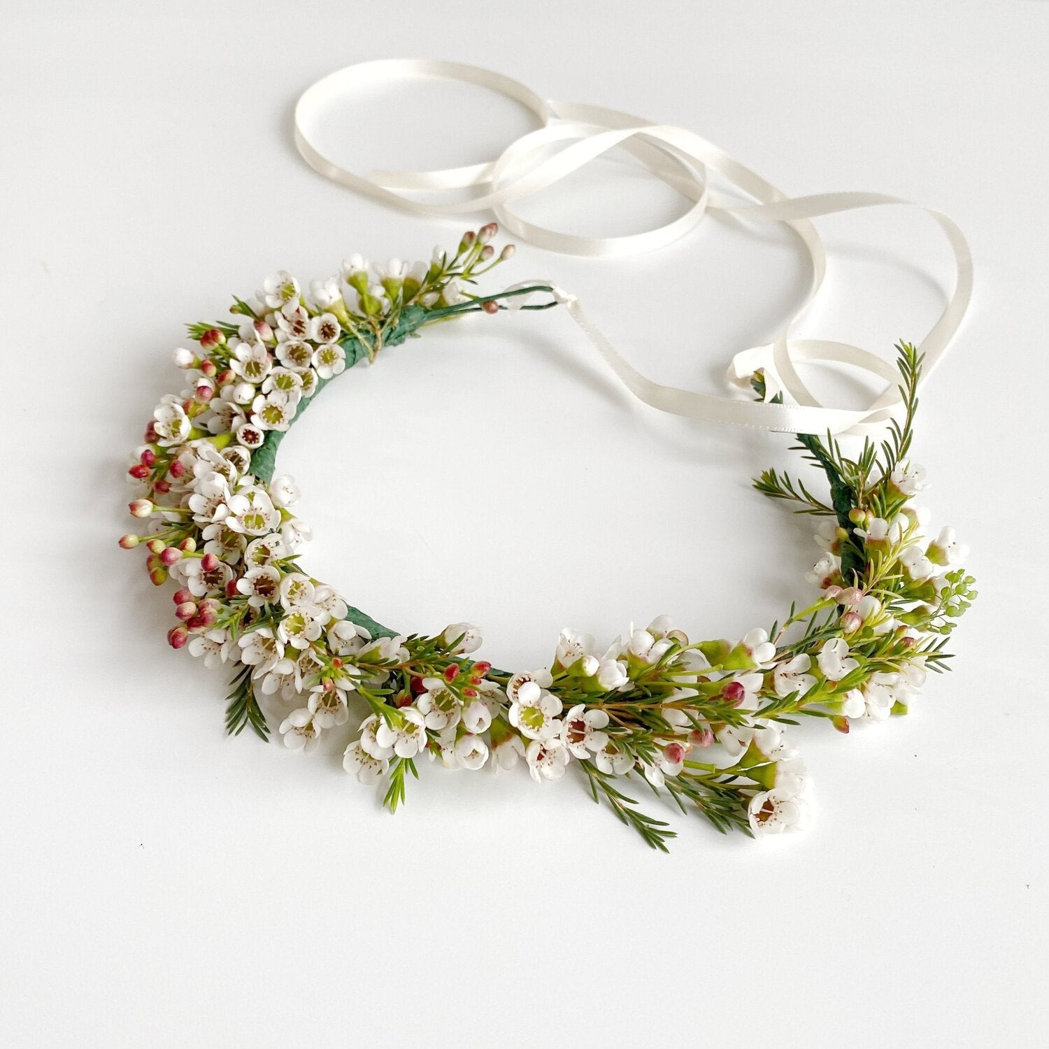 Flower crown tied with white satin ribbon featuring varying white flowers. Arranged in Memphis, TN by Everbloom Design.