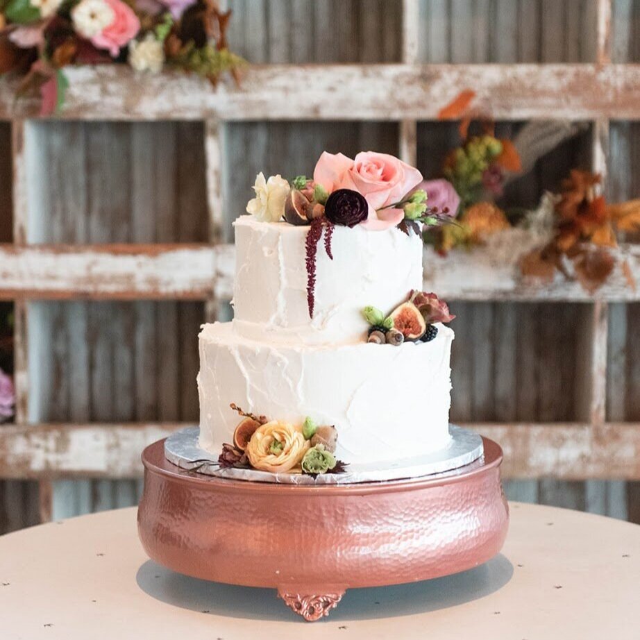 Picture of white wedding cake featuring small flower arrangements on varying levels of the cake.  Floral arrangement completed by Everbloom Design a Memphis, Tennessee based floral studio.